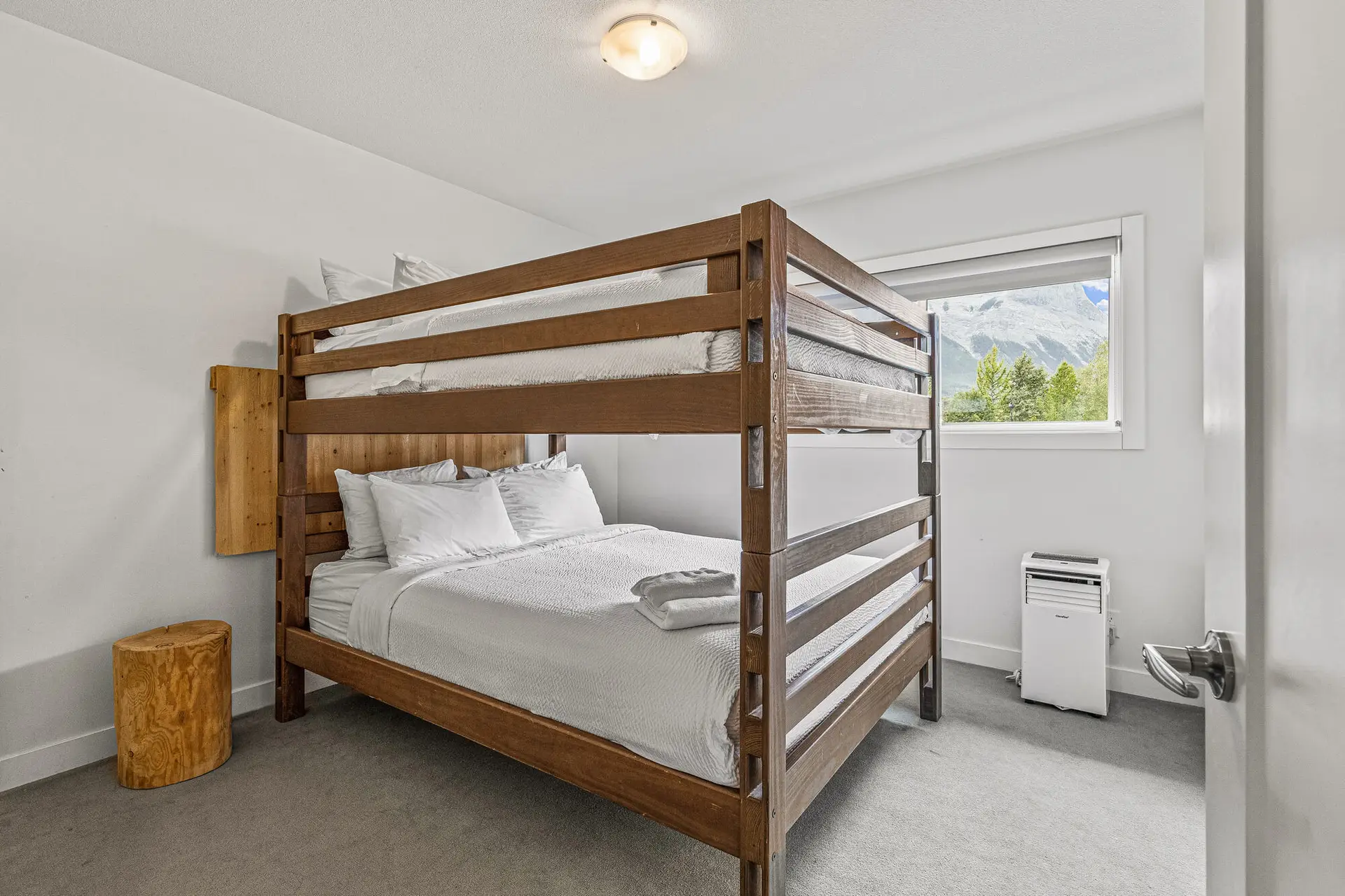 Bunk beds in a bright bedroom with a mountain view at Basecamp Resorts Canmore