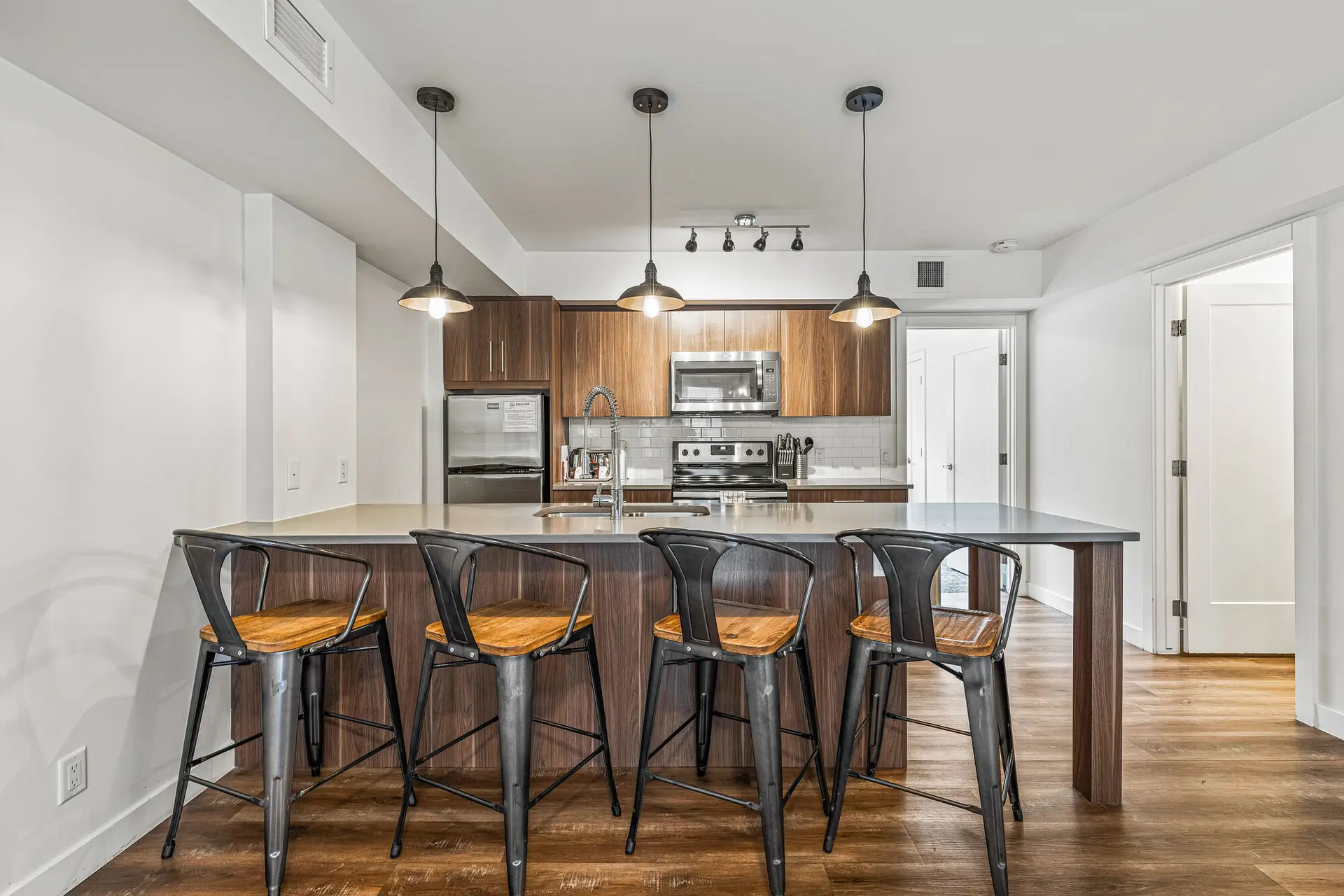Modern kitchen island with bar stools in a Basecamp Resorts Canmore one bedroom suite.