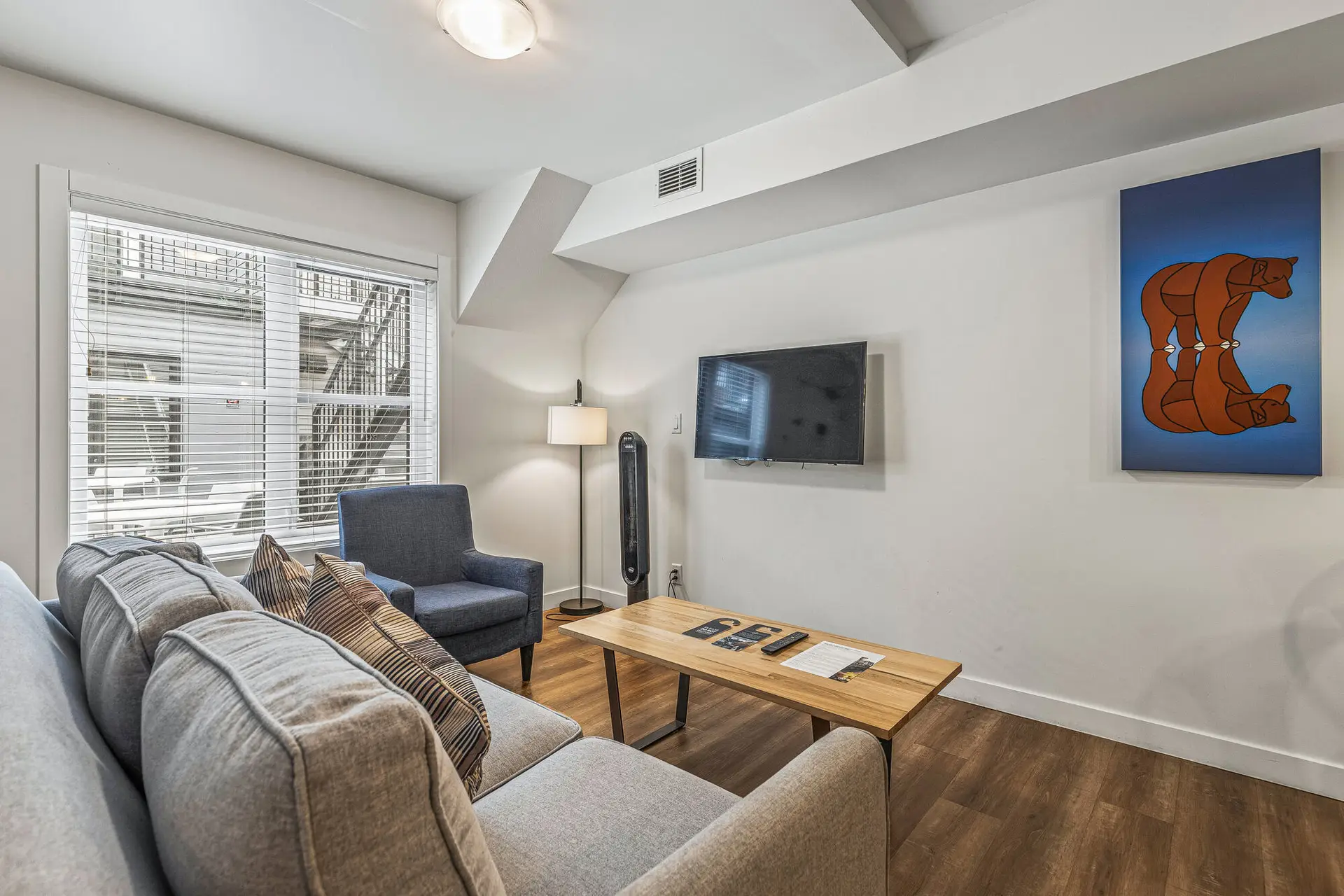 Basecamp Resorts Canmore one-bedroom suite living room with couch, coffee table, and artwork