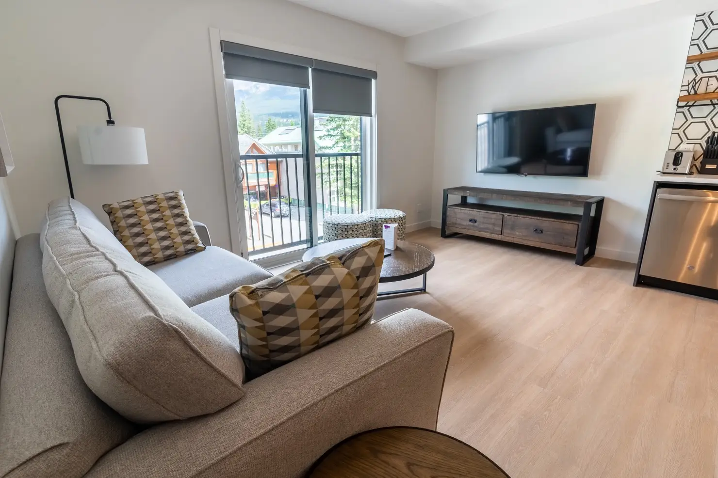 Basecamp Suites Canmore two-bedroom suite living area with sofa, coffee table, and TV