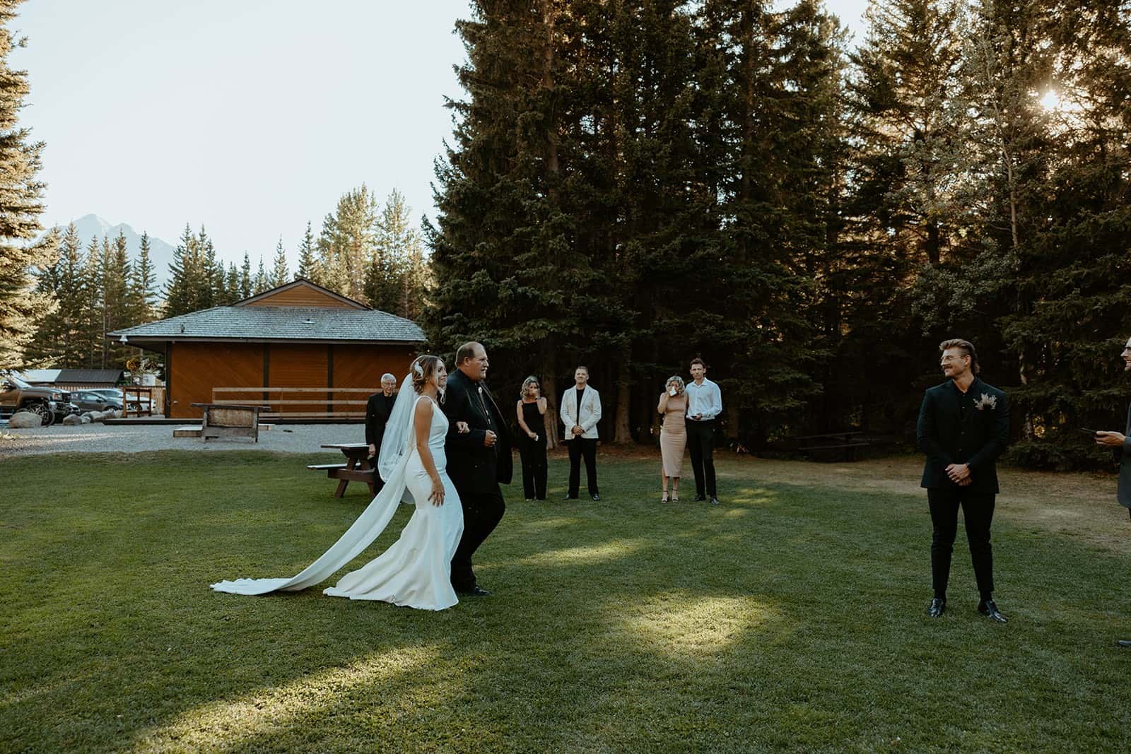Bride and groom at an outdoor wedding ceremony at Sundance, with guests watching.