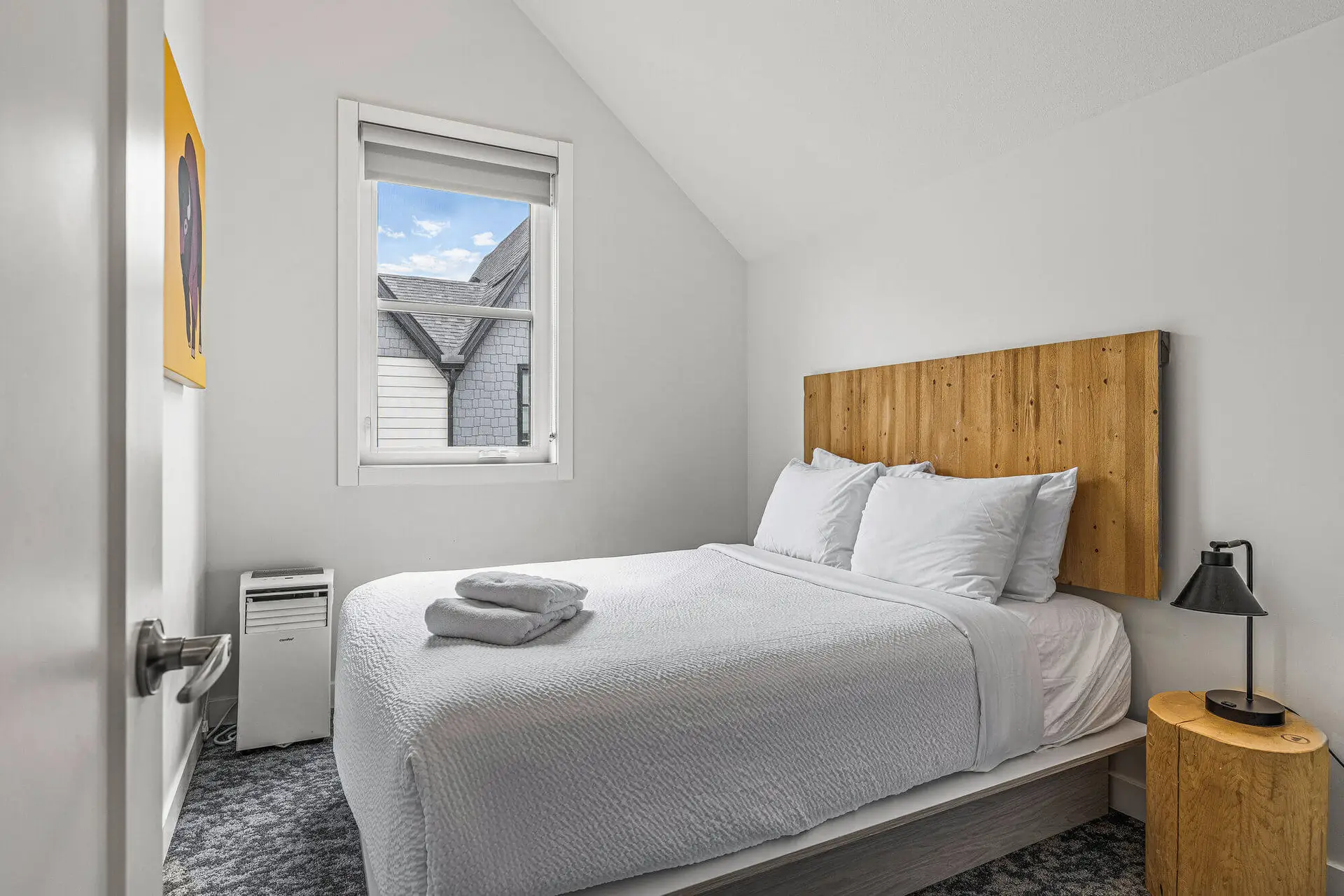 Bedroom in Basecamp Resorts Canmore Six Bedroom Suite with queen bed and wooden headboard.