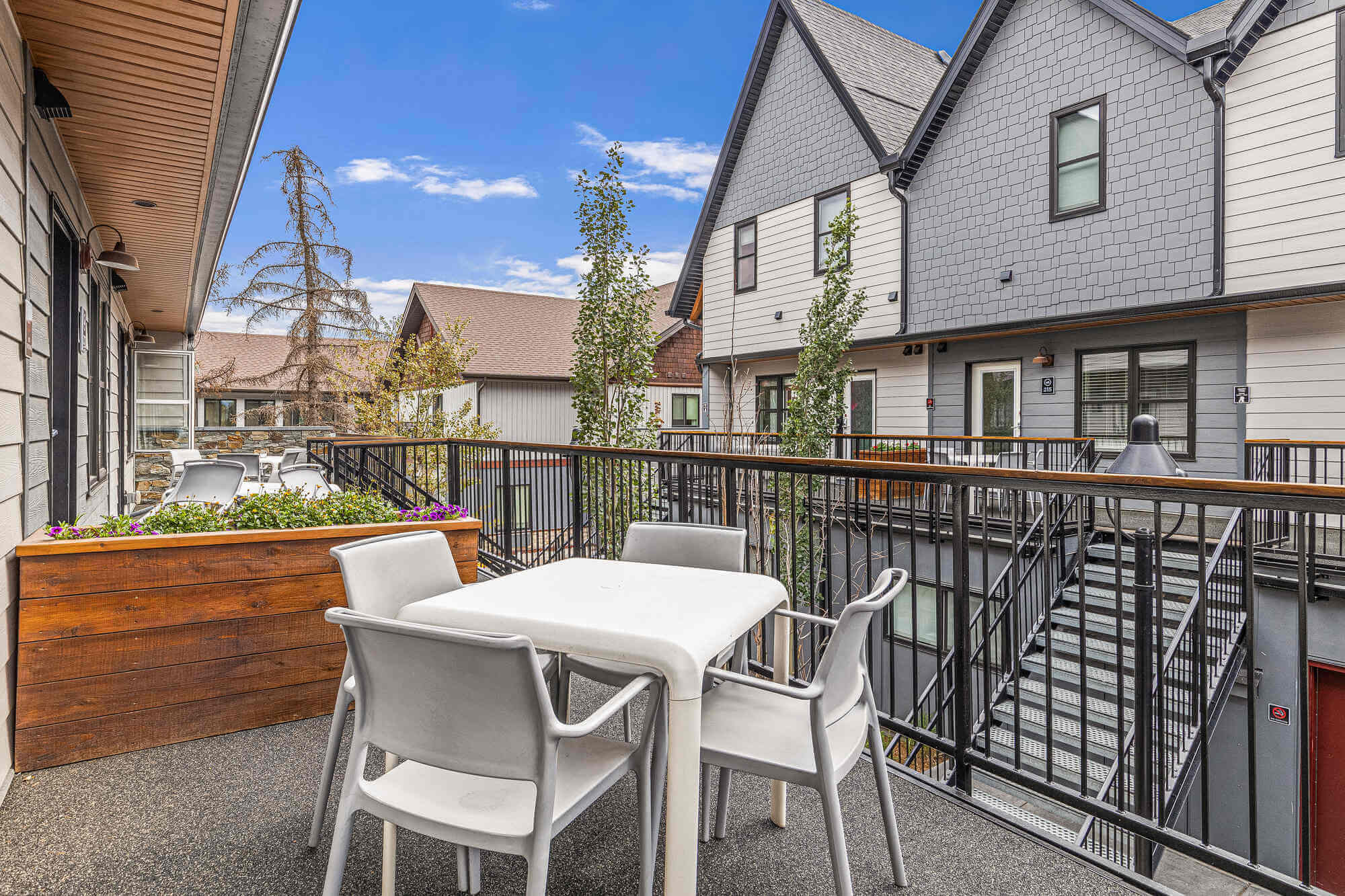 Balcony of Basecamp Resorts Canmore six-bedroom suite with outdoor dining set.