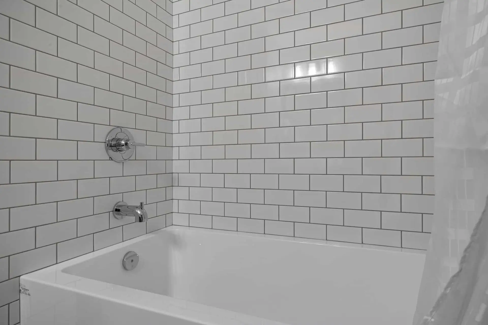 Deluxe Queen room bathtub with white subway tile and chrome fixtures at Basecamp Northwinds Canmore.