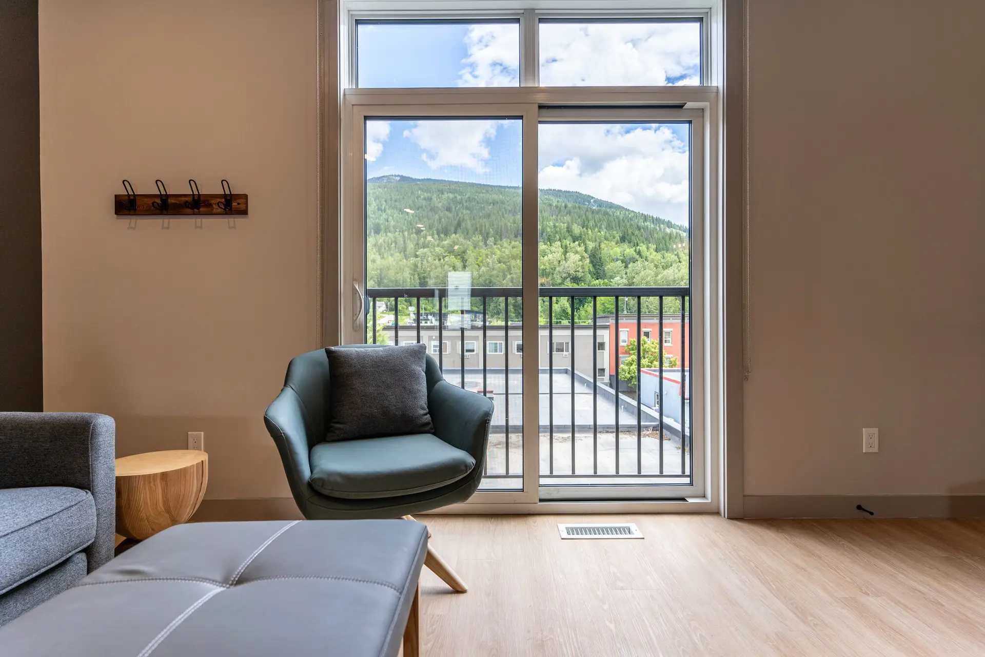Interior of Basecamp Suites Four Bedroom Suite with wooden floors, teal chair, balcony