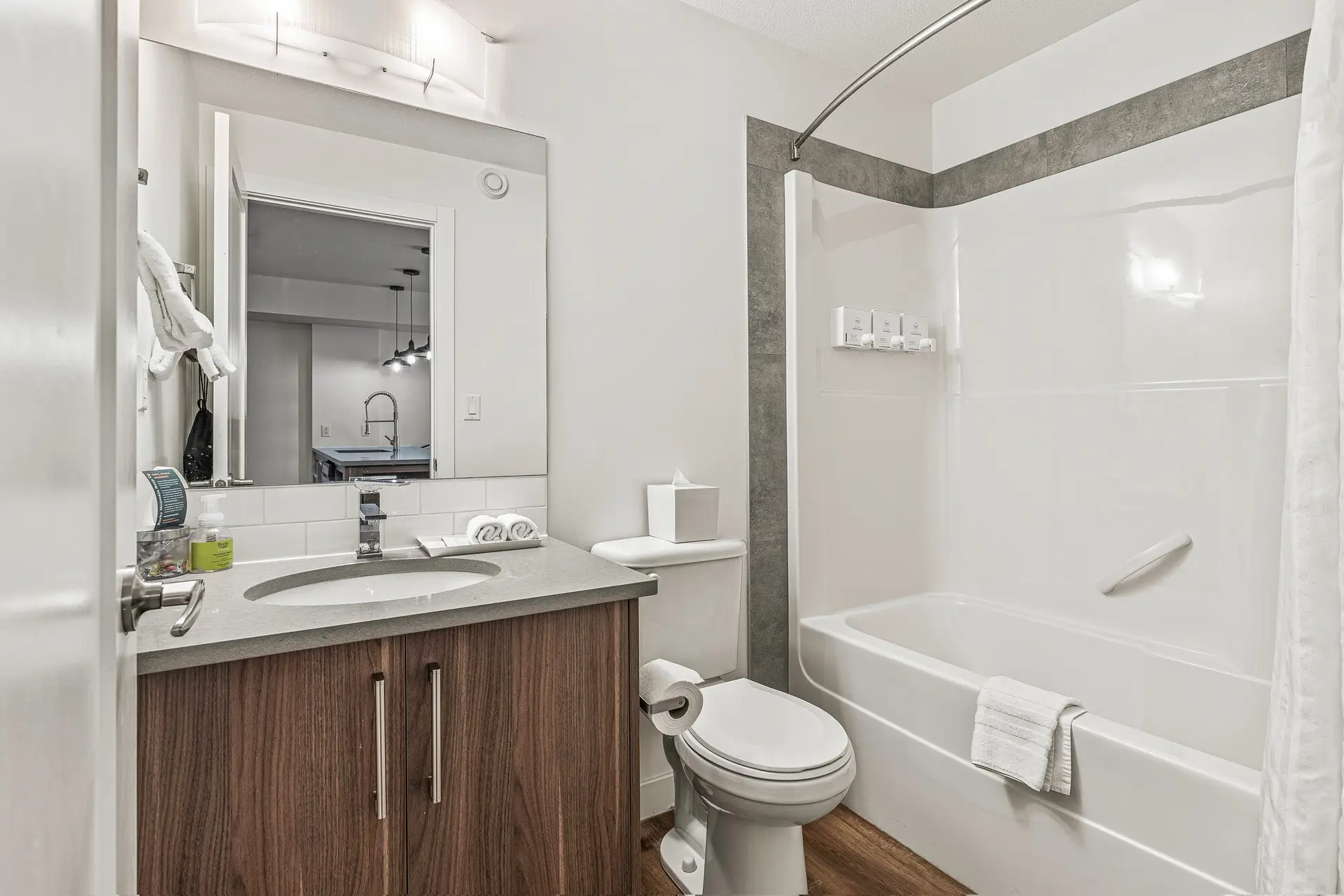 Modern bathroom in a Canmore one bedroom suite with a vanity, toilet, and bathtub.