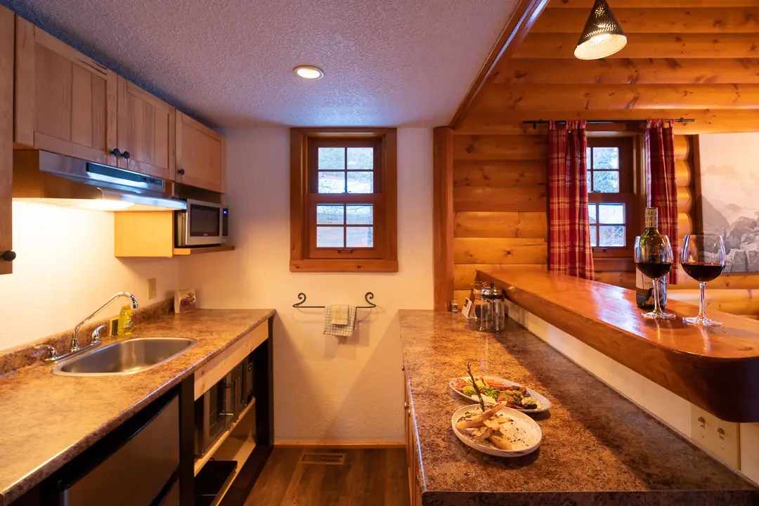 Basecamp Baker Creek cabin kitchen with wood accents and a wine bar.