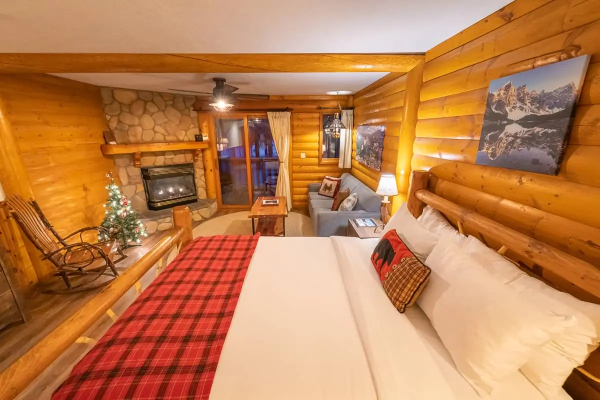 Basecamp Baker Creek Jacuzzi Suite: cozy log room with fireplace, bed, sofa bed