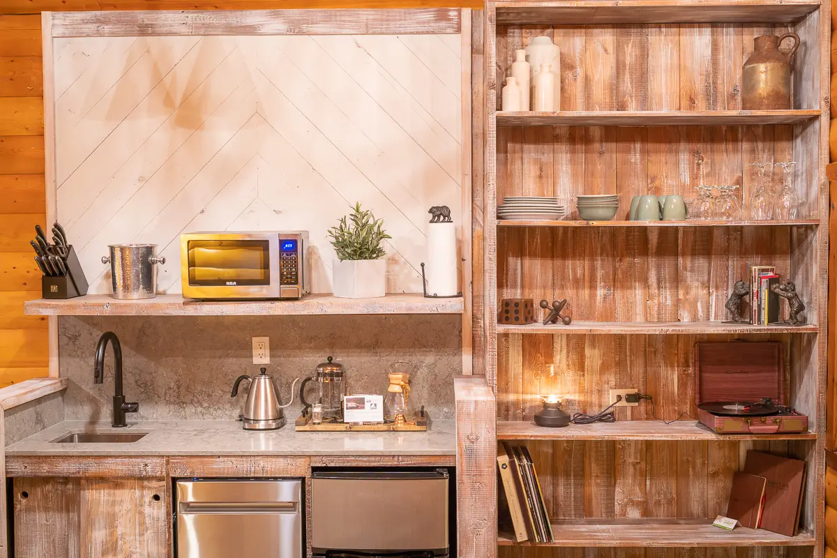 Basecamp Baker Creek cabin kitchenette with microwave, coffee maker, and rustic shelving