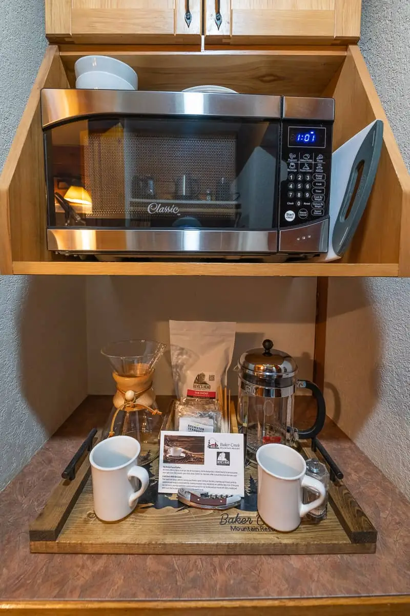 Baker Creek Queen Cabin kitchenette with microwave, coffee maker, and mugs.