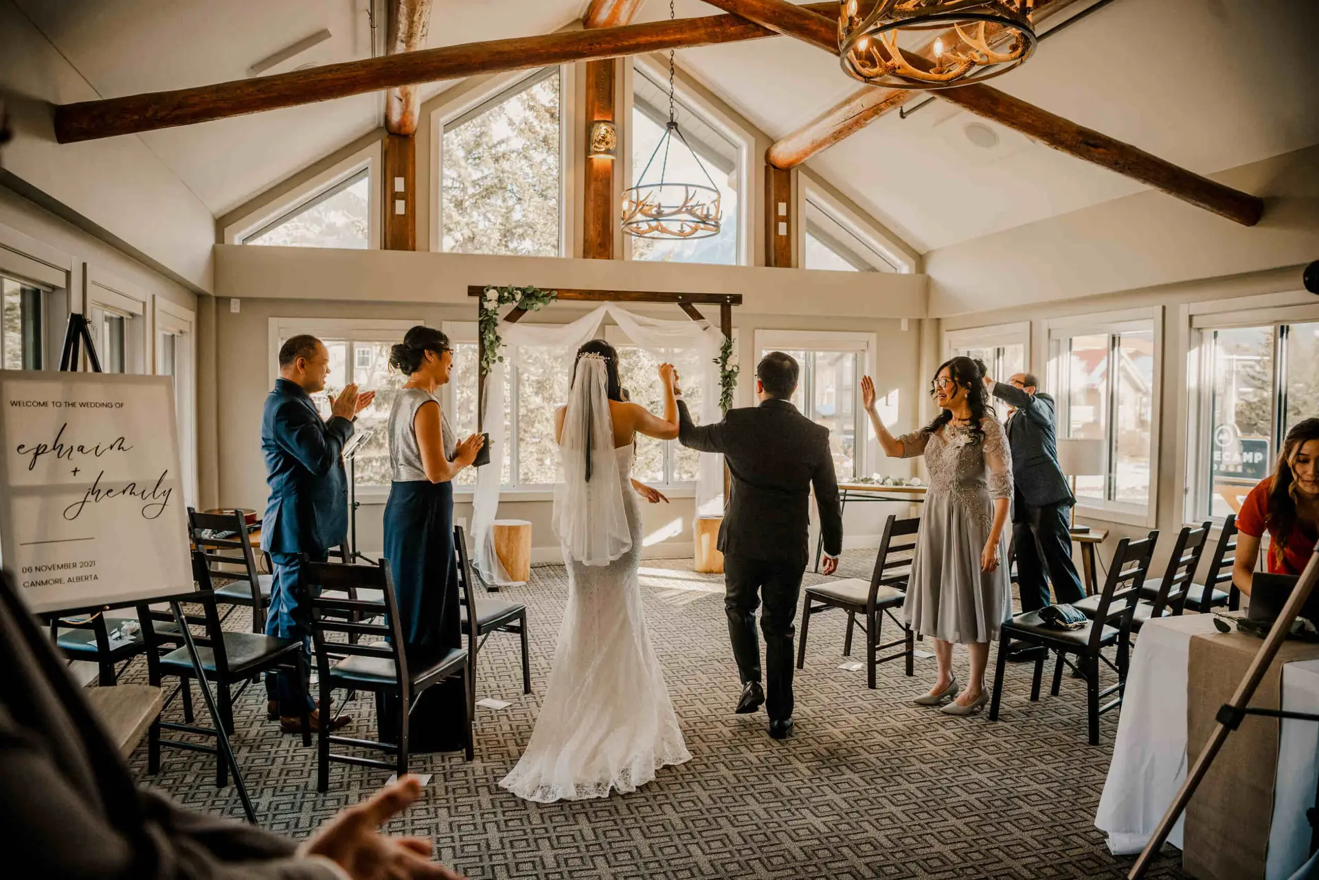 Wedding ceremony at Basecamp Suites Canmore with bride and groom walking down aisle.