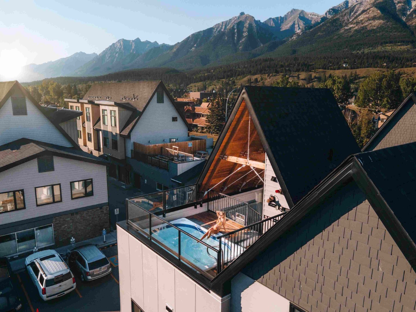 Woman relaxing in a rooftop hot tub at Basecamp Resorts Canmore with mountain views