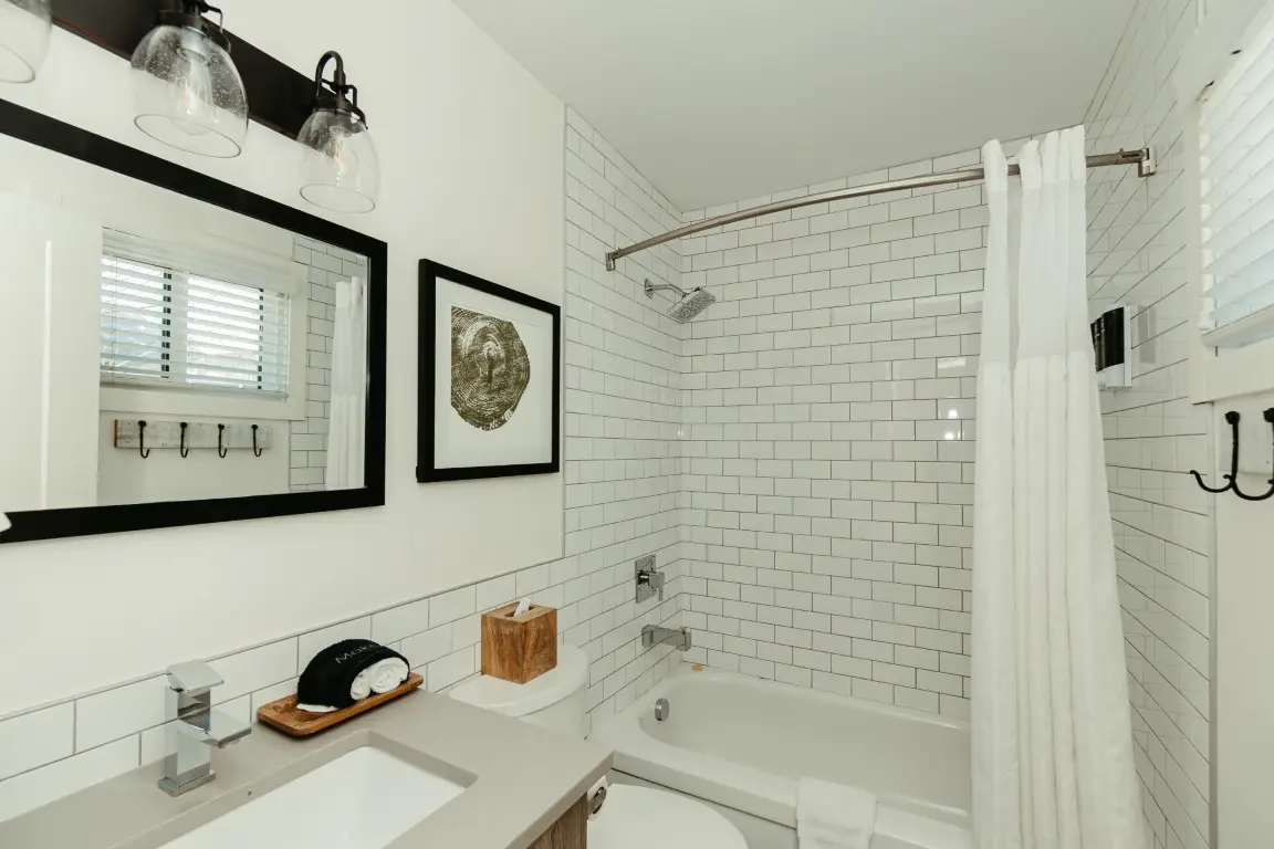 Modern bathroom with subway tile shower, vanity, and bathtub in Canmore King Room
