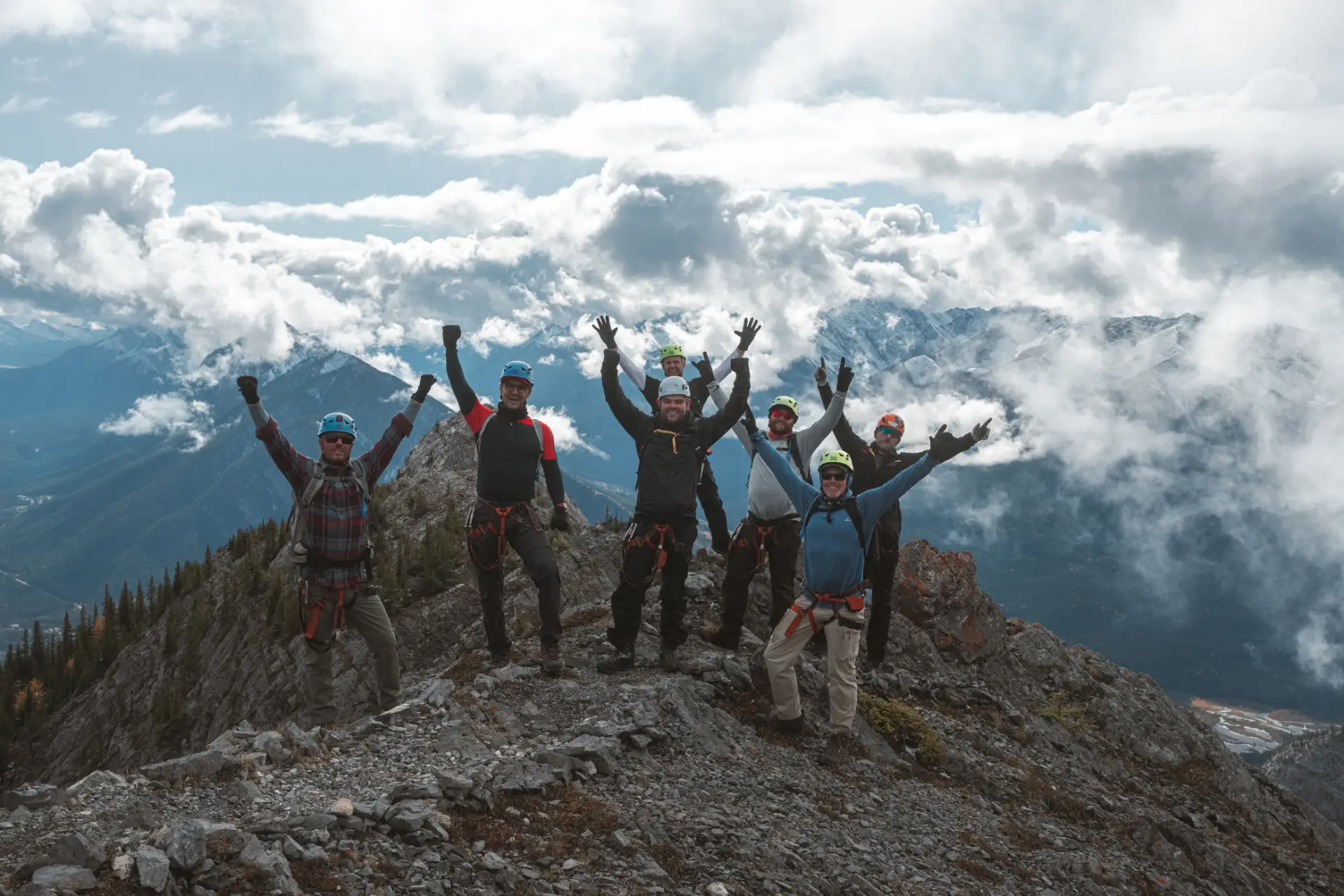 Group of people in climbing gear celebrating on a mountain peak