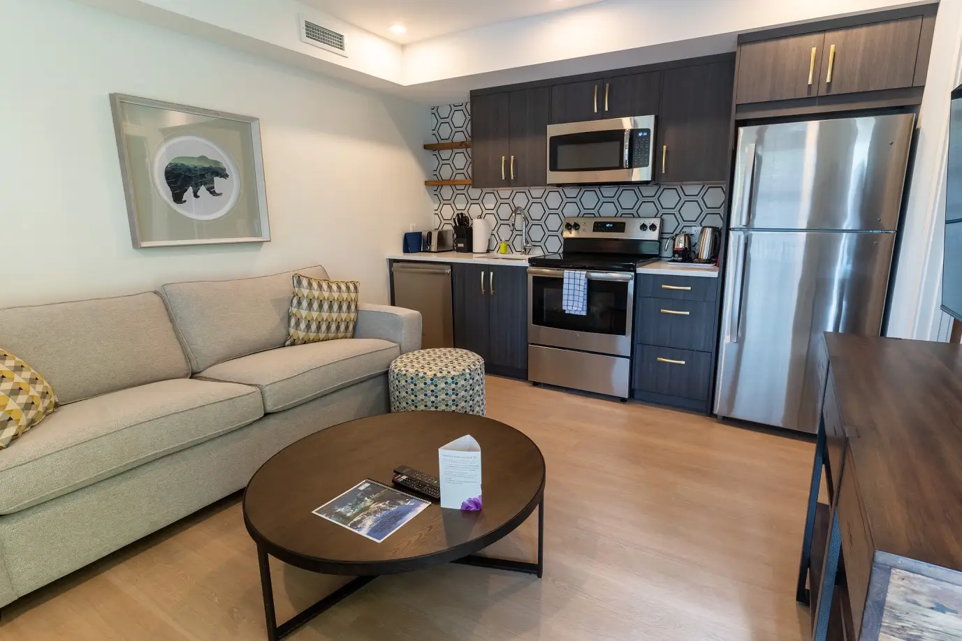 Basecamp Suites Canmore one-bedroom suite living area with sofa, coffee table, and kitchenette.