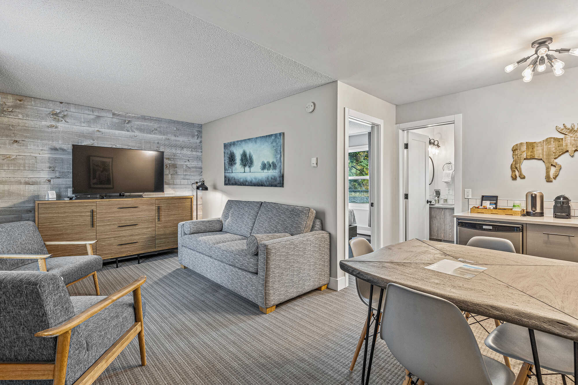 Basecamp Lamphouse Canmore Queen Suite living area with sofa, dining table, and kitchenette.