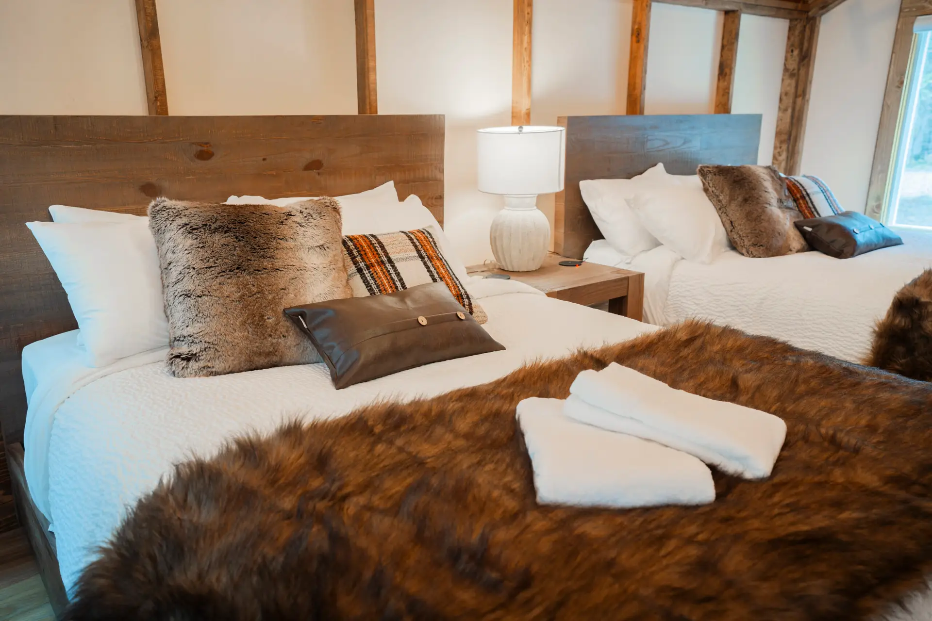Deluxe glamping tent bedroom with two queen beds and rustic decor