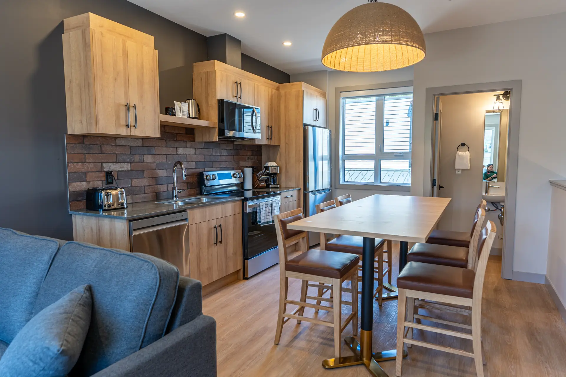 Modern kitchen and dining area in a Basecamp Suites Revelstoke two-bedroom queen suite.