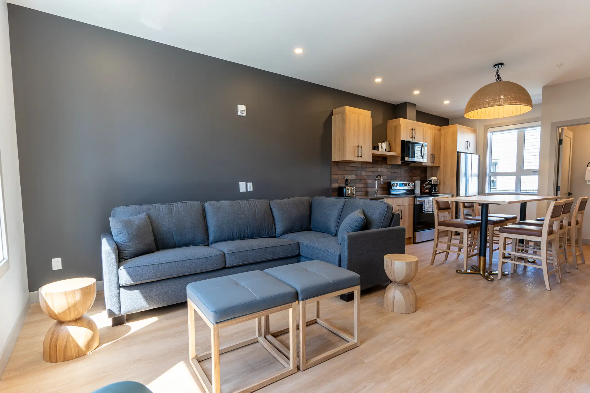 Basecamp Suites Revelstoke Two Bedroom Queen Suite living area with sofa, dining table, and kitchen.