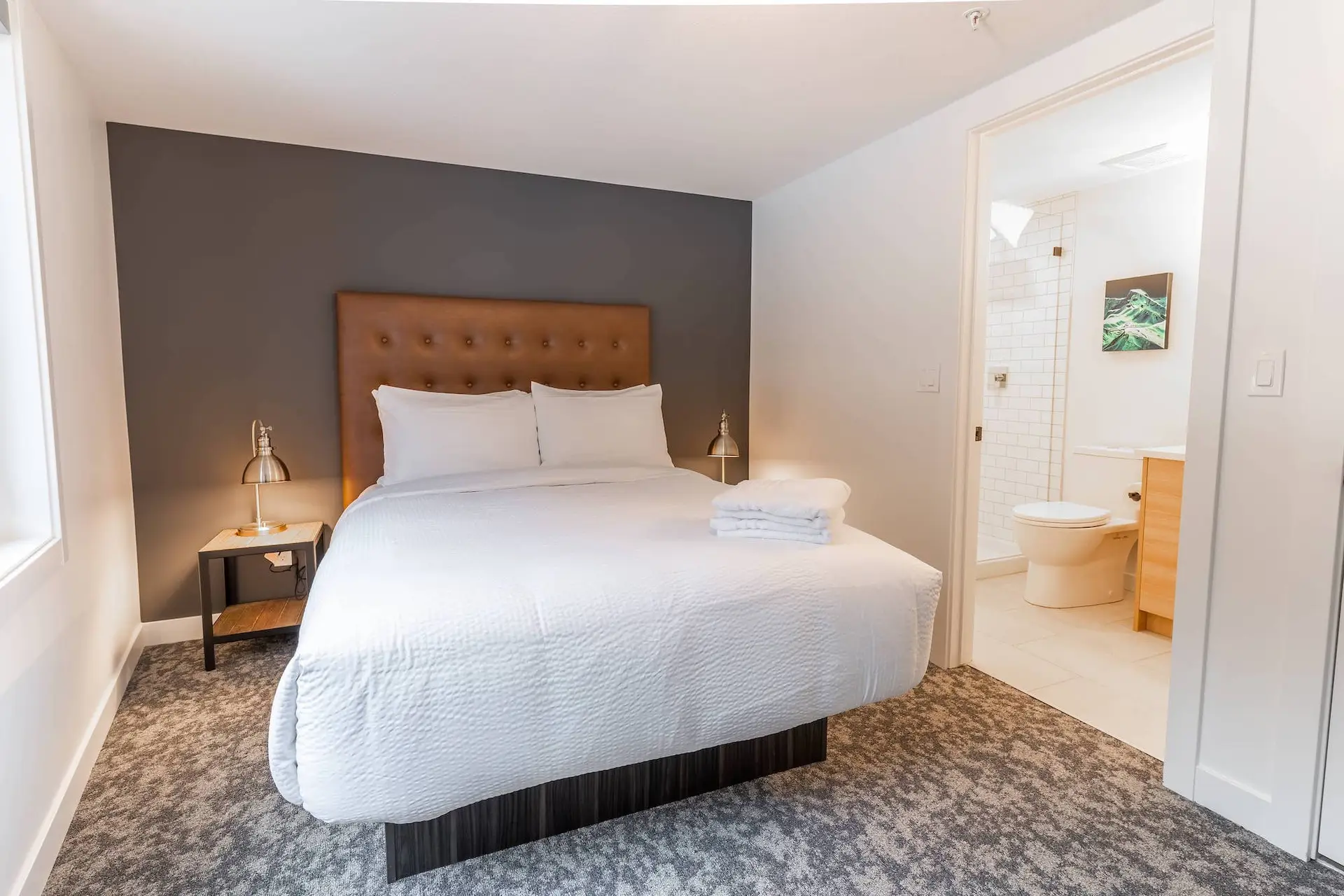 Revelstoke four-bedroom suite: king bed, ensuite bathroom, modern decor.