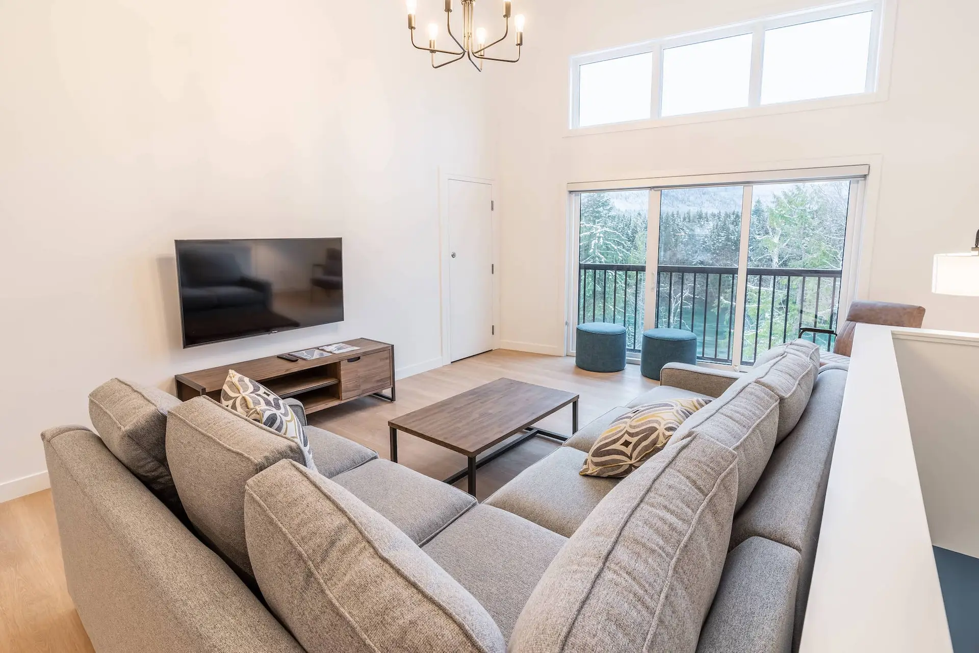 Revelstoke four bedroom suite living room with large sectional sofa and mountain view