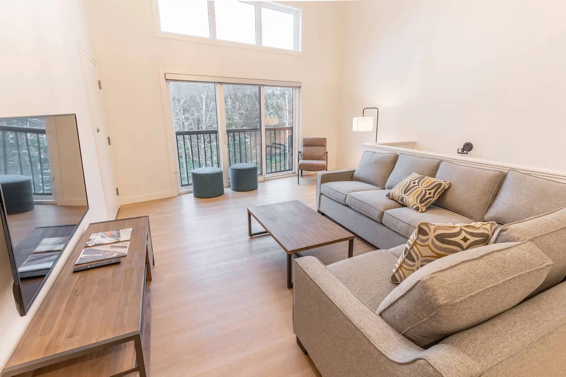 Revelstoke four bedroom suite living room with sectional sofa and balcony view