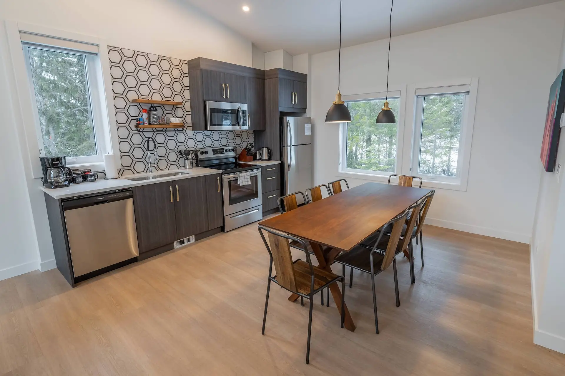 Modern kitchen and dining area in Basecamp Resorts Revelstoke three-bedroom suite.