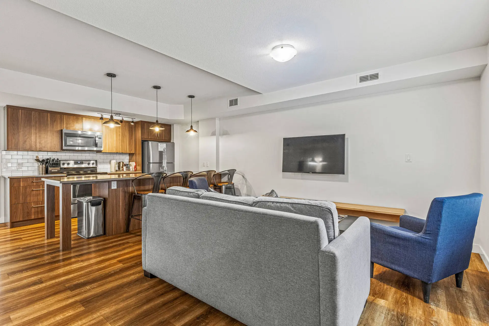 Modern living room and kitchen in Basecamp Resorts Canmore three-bedroom suite.