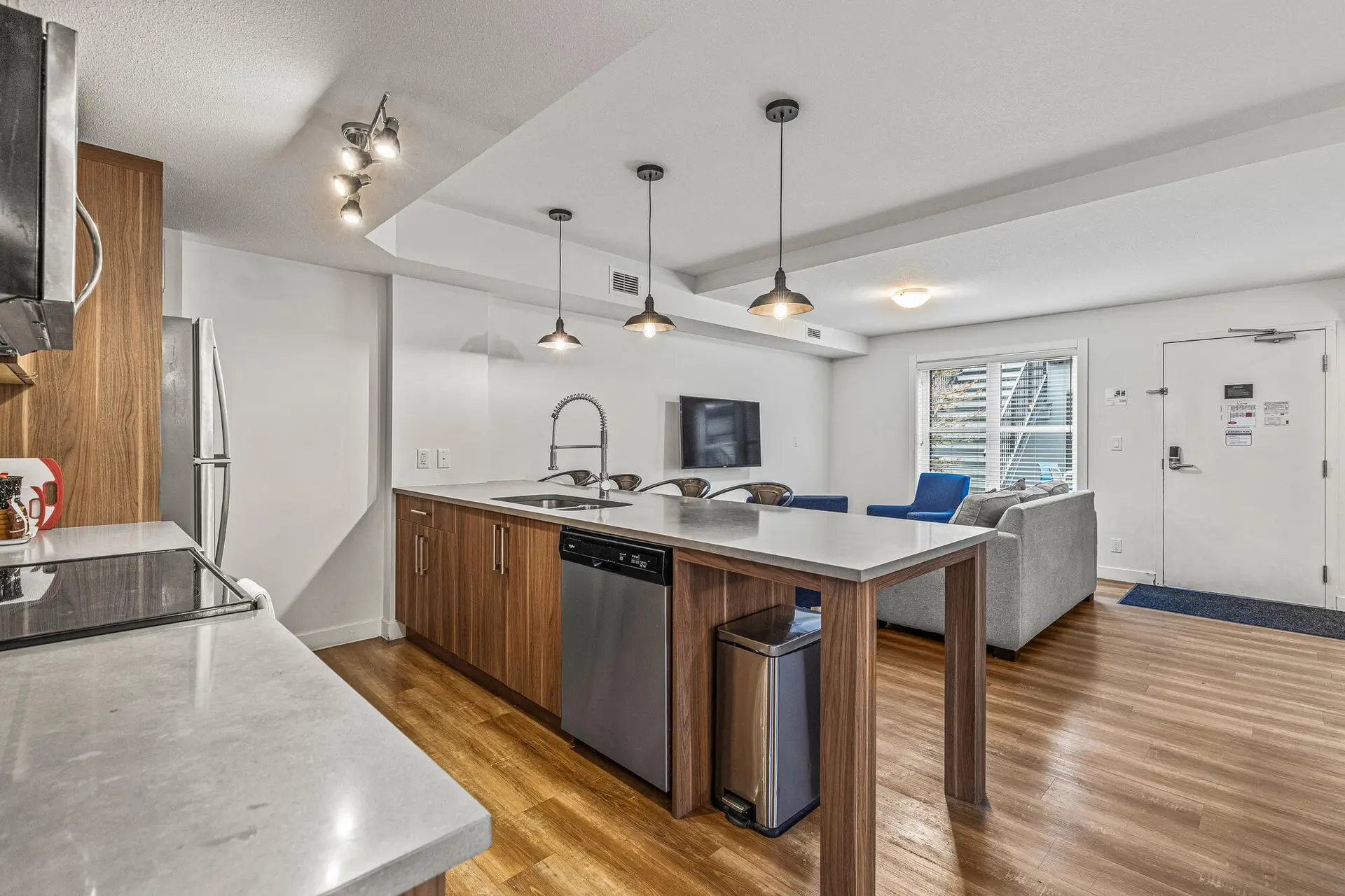Modern kitchen and living area in a Basecamp Resorts Canmore three-bedroom suite.