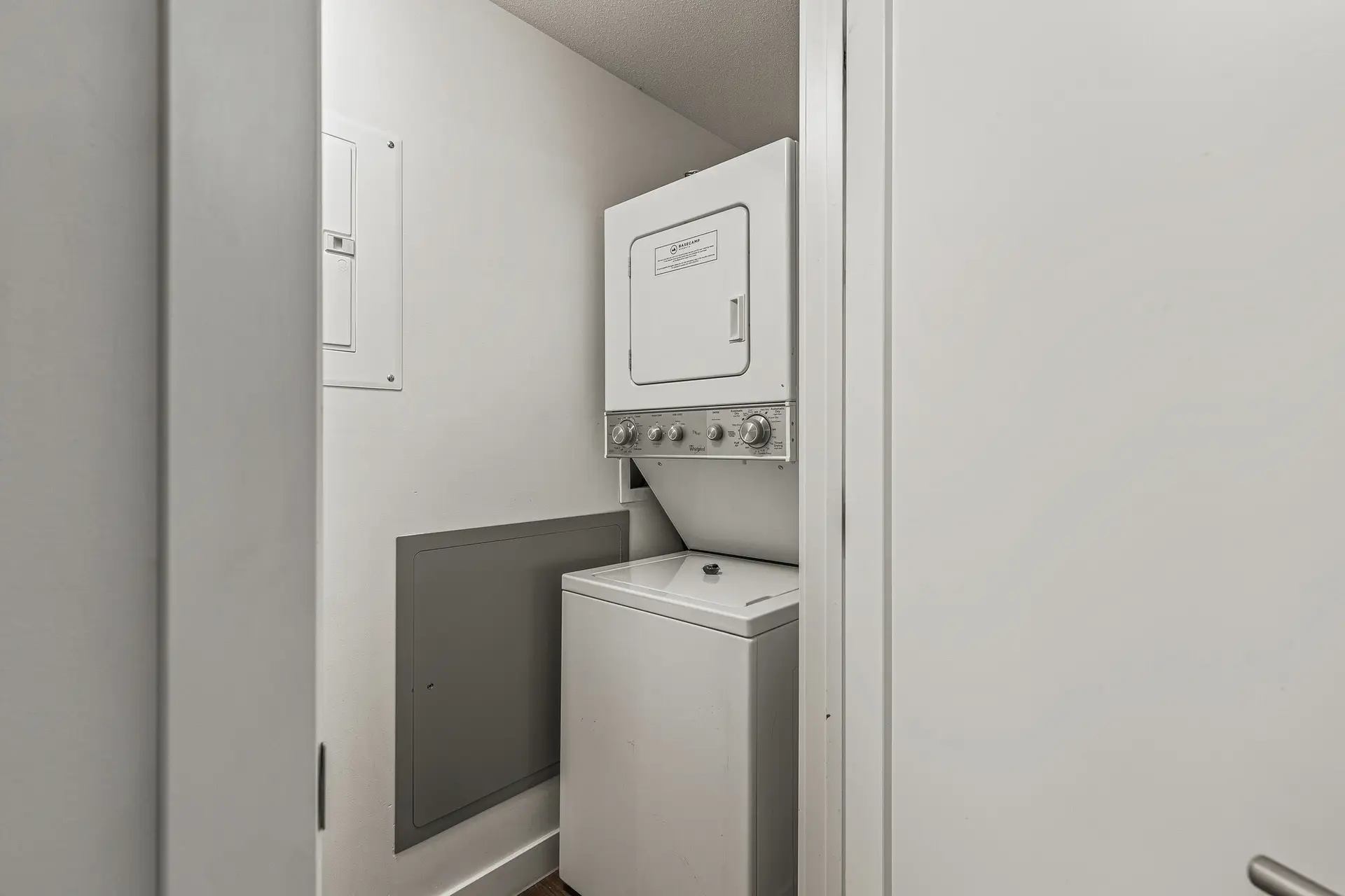 Stackable washer and dryer in a compact laundry closet at Basecamp Resorts Canmore.