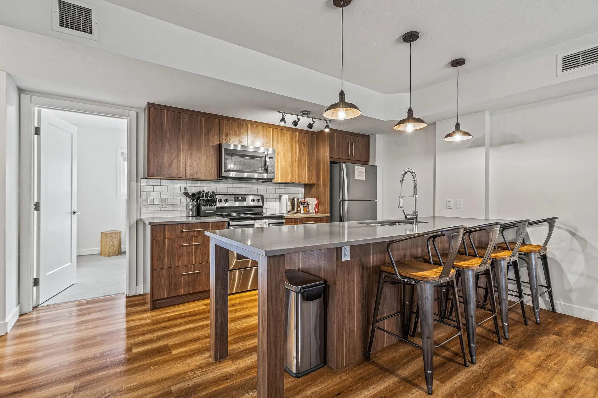 Modern kitchen island with bar stools in a spacious condo