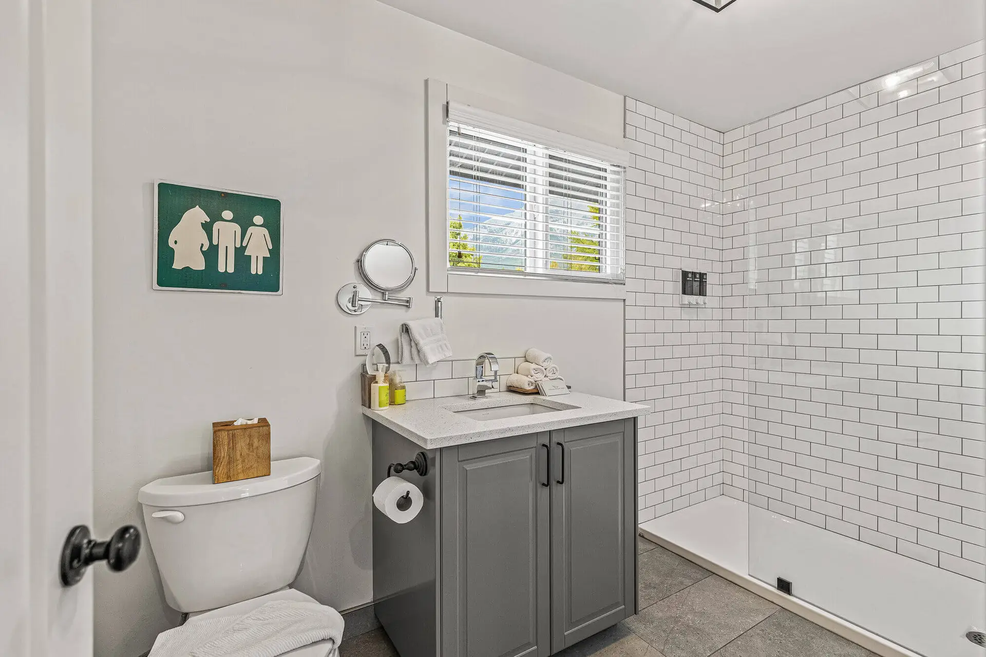 Lamphouse Apartment Canmore: Modern bathroom with white subway tile shower and grey vanity