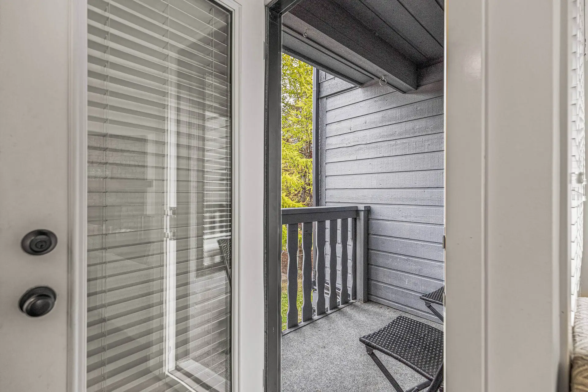 Balcony view from Basecamp Lamphouse apartment in Canmore with chairs and railing.